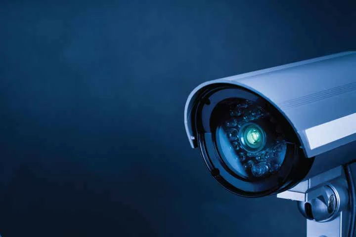 Close view of a surveillance camera in blue light